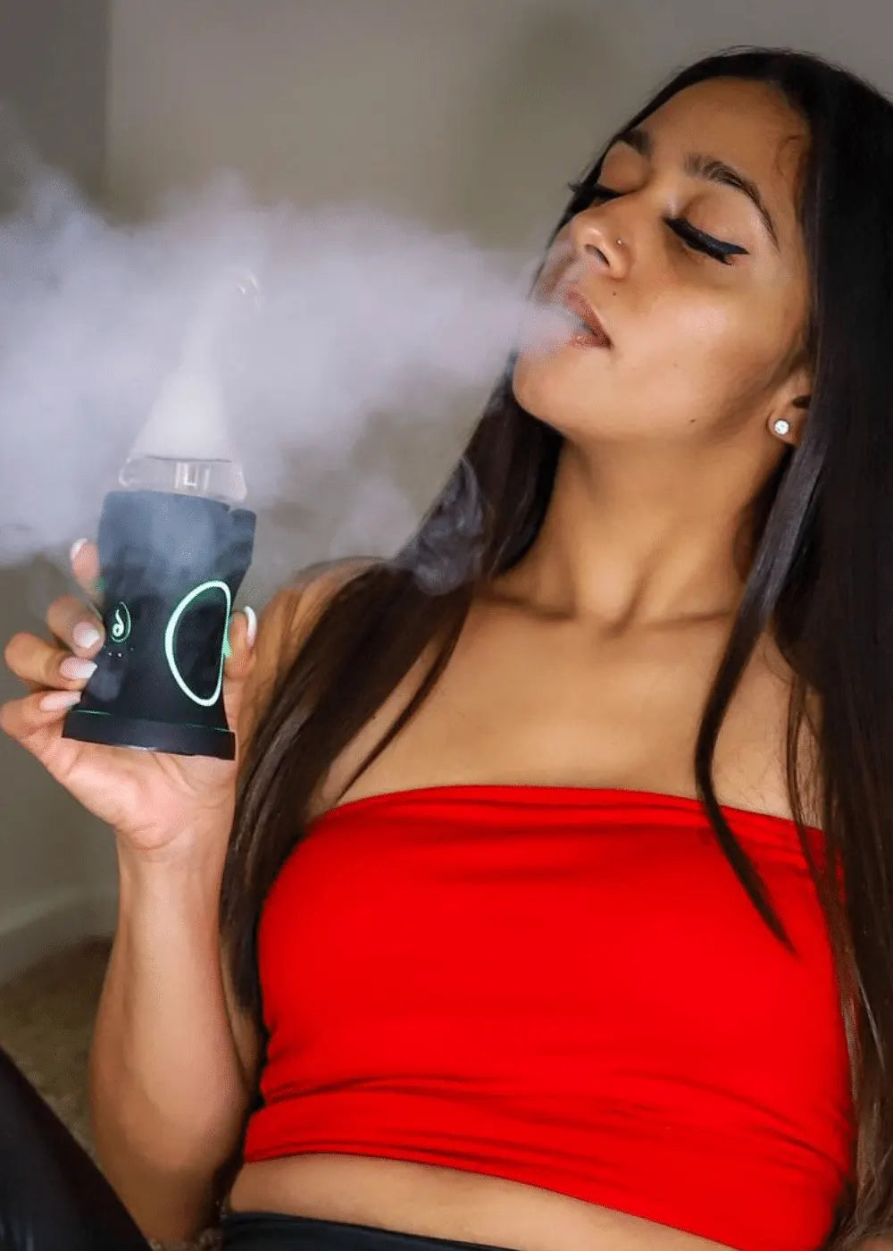 woman holding Dr. Dabber Boost Evo exhaling vapor